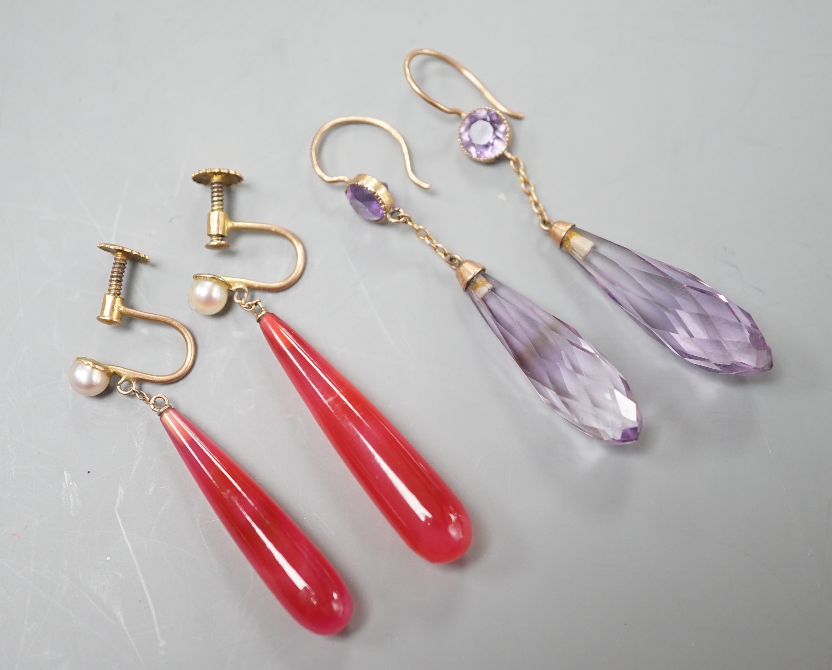 A pair of yellow metal and two facetted amethyst drop earrings, overall 49mm and a pair of 9ct, red carnelian? and seed pearl set drop earrings.